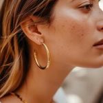 close-up-of-a-woman-ear-adorned-with-gold-hoop-earrings-in-natural-light-photo